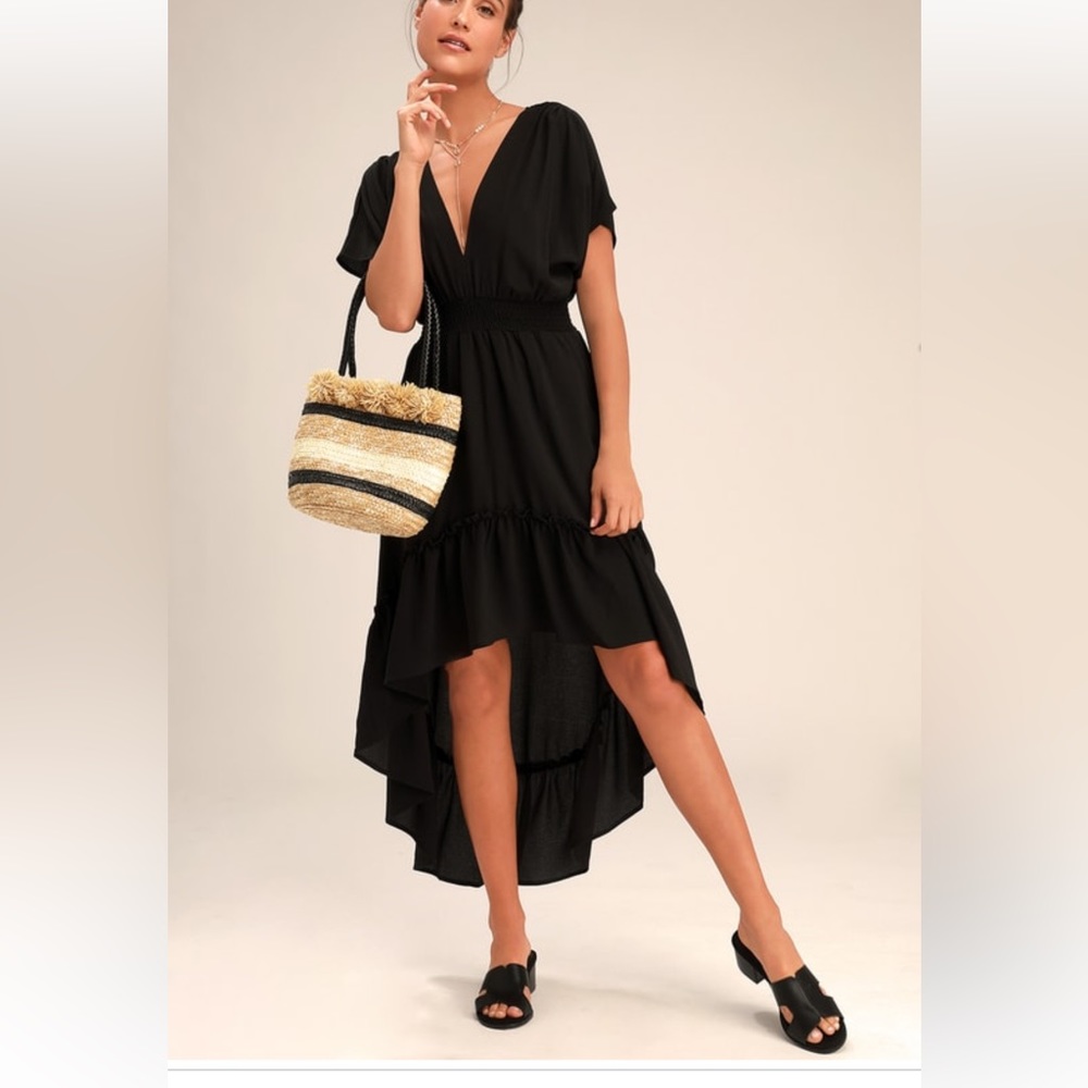 Black dress with ruffle bottom. Tassel tie in back with a deep V opening. Size M